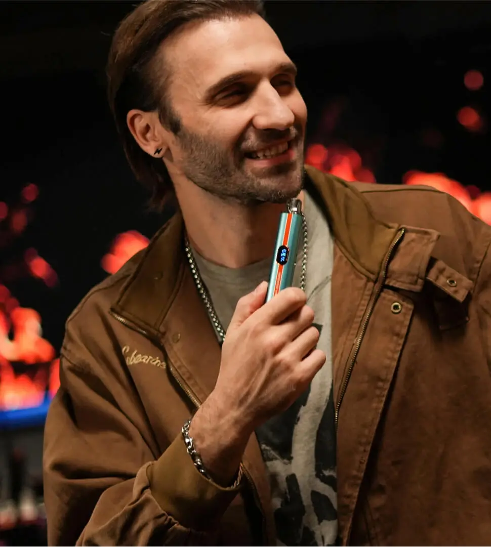 A man vaping indoors in the evening with the VAPORESSO VIBE, showcasing its 4.5ml pod designed to last for vaping needs from morning until night on a single fill.